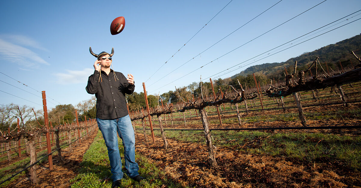 Dave Ready throwing a football in the air in a vineyard