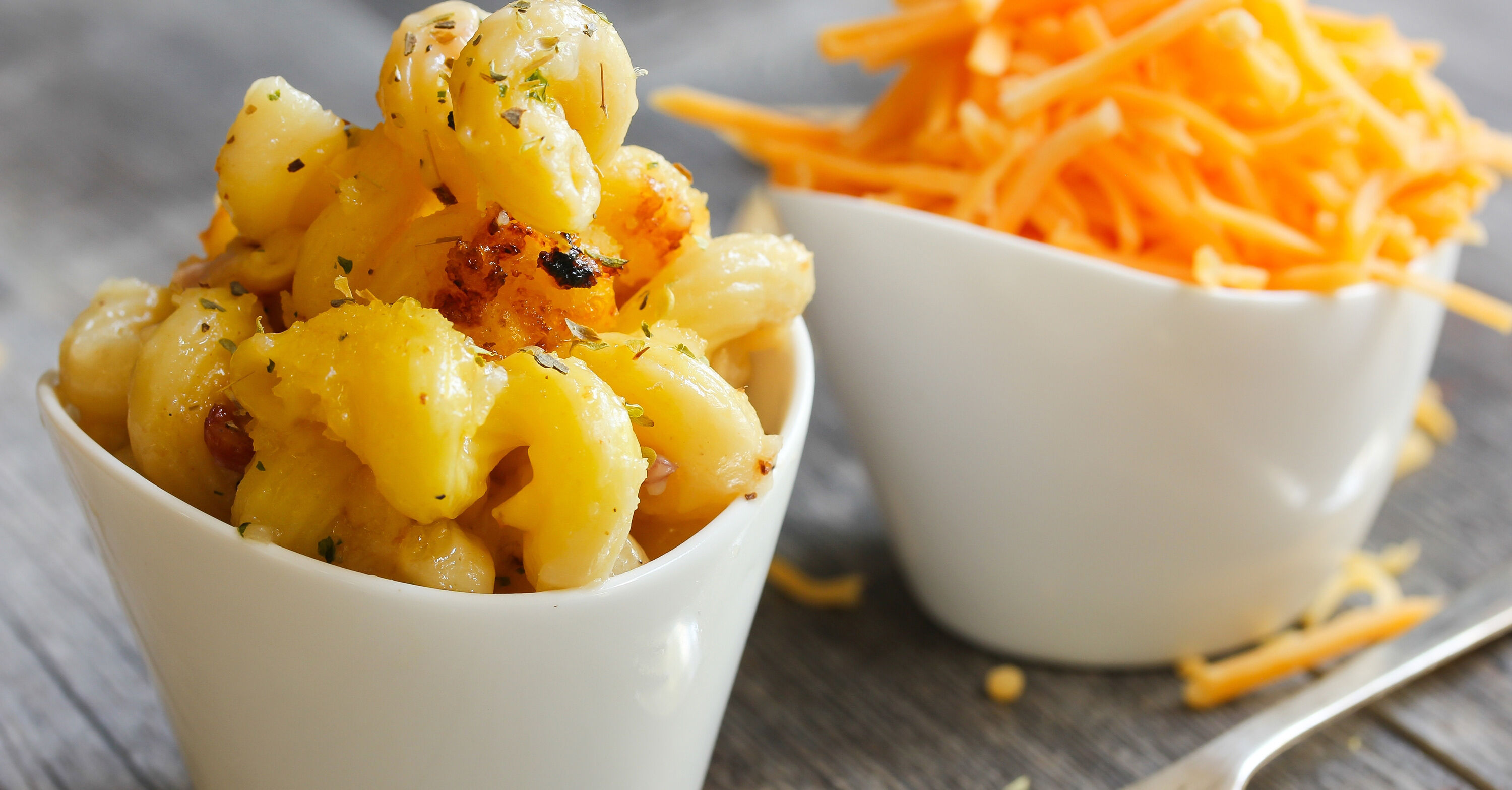 Mac and Cheese pasta with cheddar cheese in the background