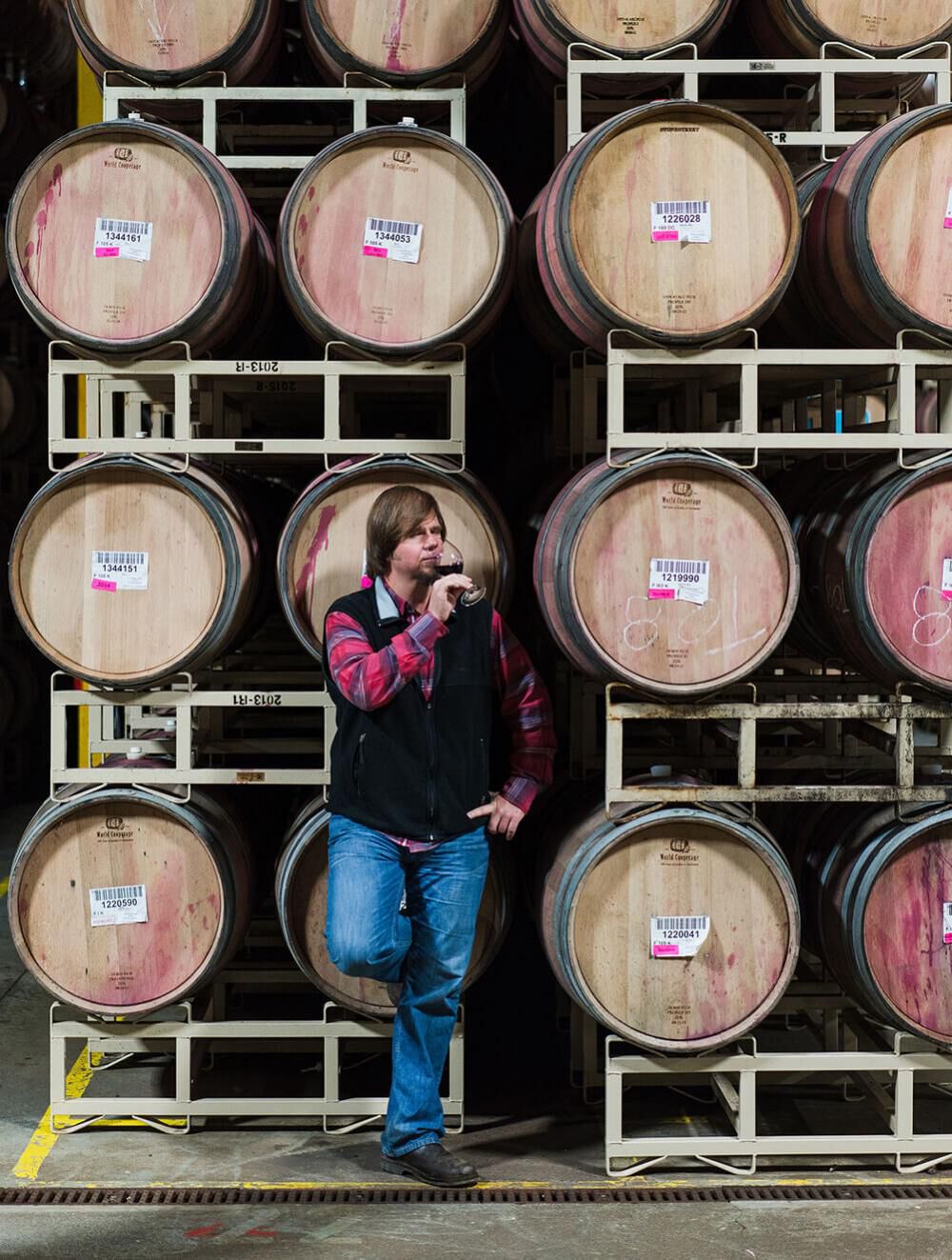 Murphy-Goode Winemaker, Dave Ready JR., standing in barrel room with a glass of wine.