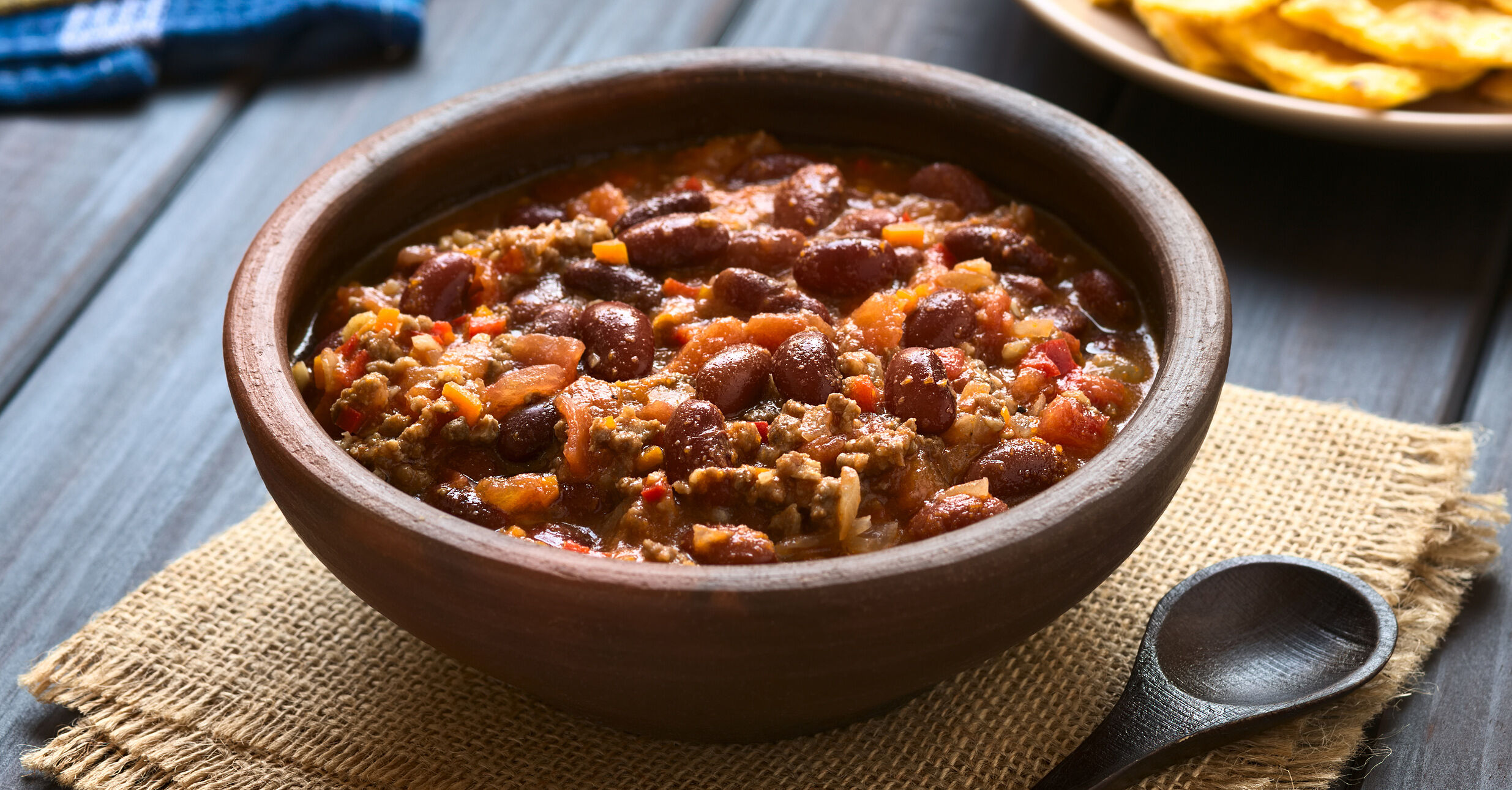 Wood bowl of Chili on a linen placemat