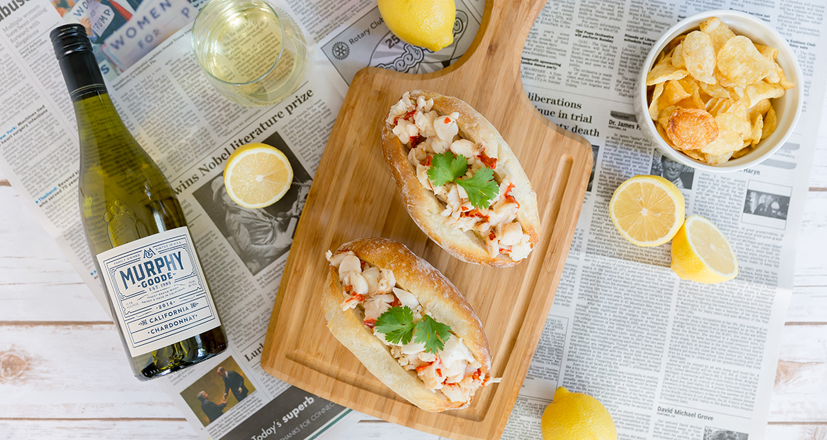 Buttery Lobster Rolls on a cheese platter and newspaper covered table