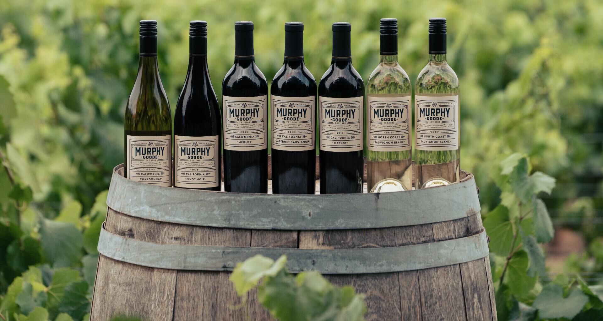 Murphy-Goode wine bottles lined up on wine barrel.